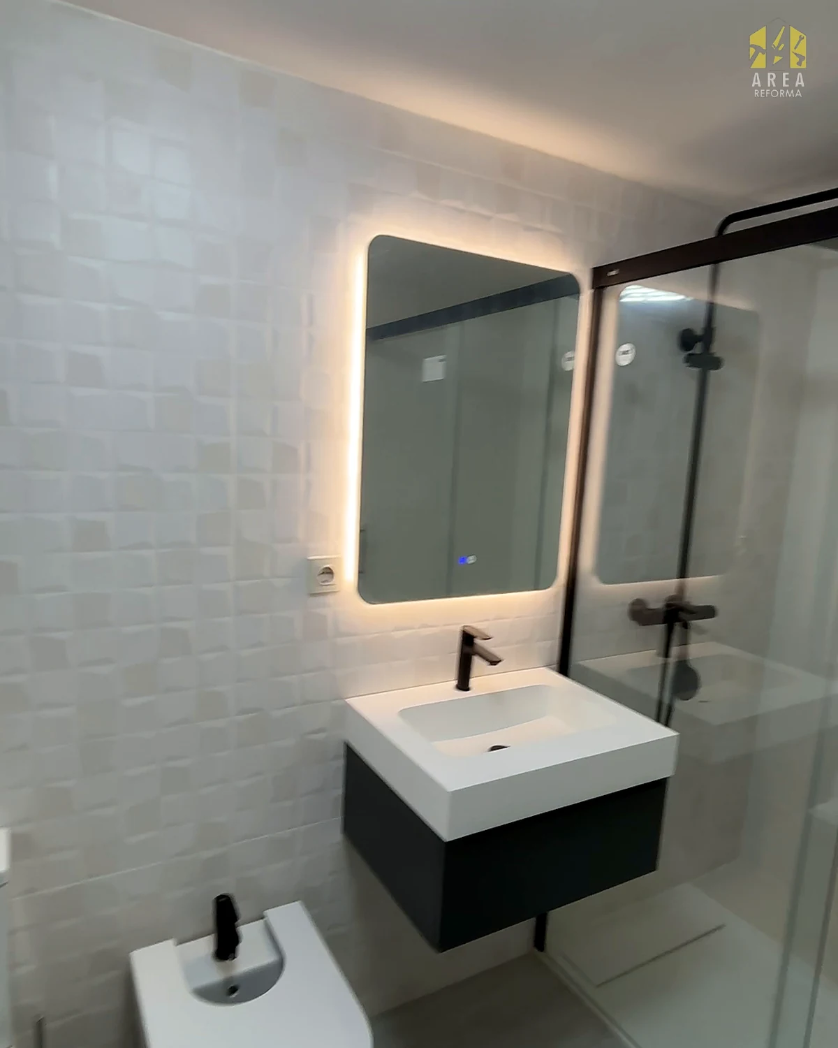 Espejo iluminado en el baño reformado
